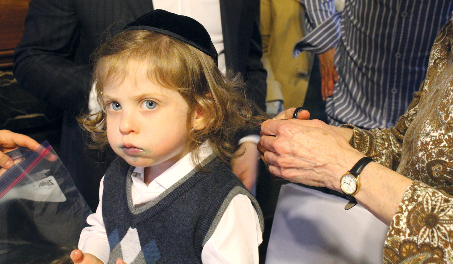As evidenced by the sticky residue around his mouth, Shalom Labkowski ate a lot of candy during his upshernish, a ritual in which a 3-year-old boy gets his first haircut. (Photo/David A.M. Wilensky)
