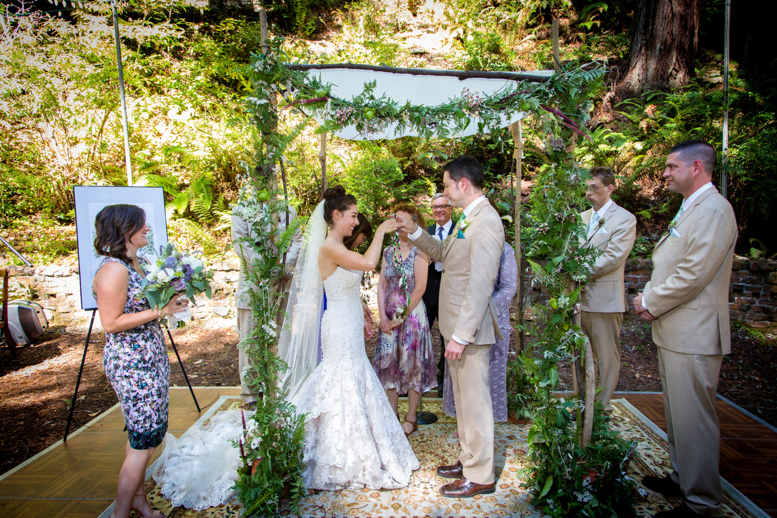 Rebecca Weissman and Kevin Lind stand beneath a chuppah made by her stepfather and decorated by her friends
