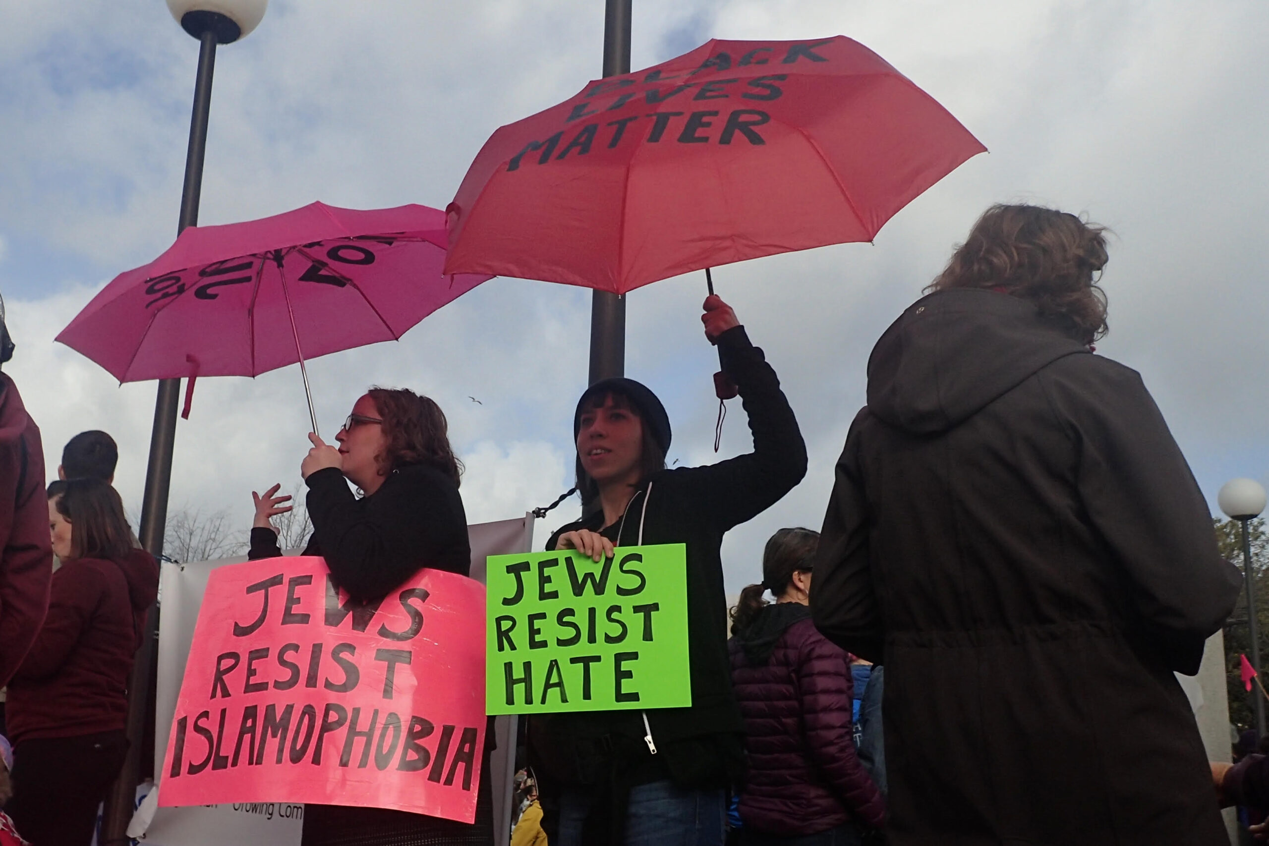 Two women hold signs that say "Jews resist Islamophobia" and "Jews against hate"