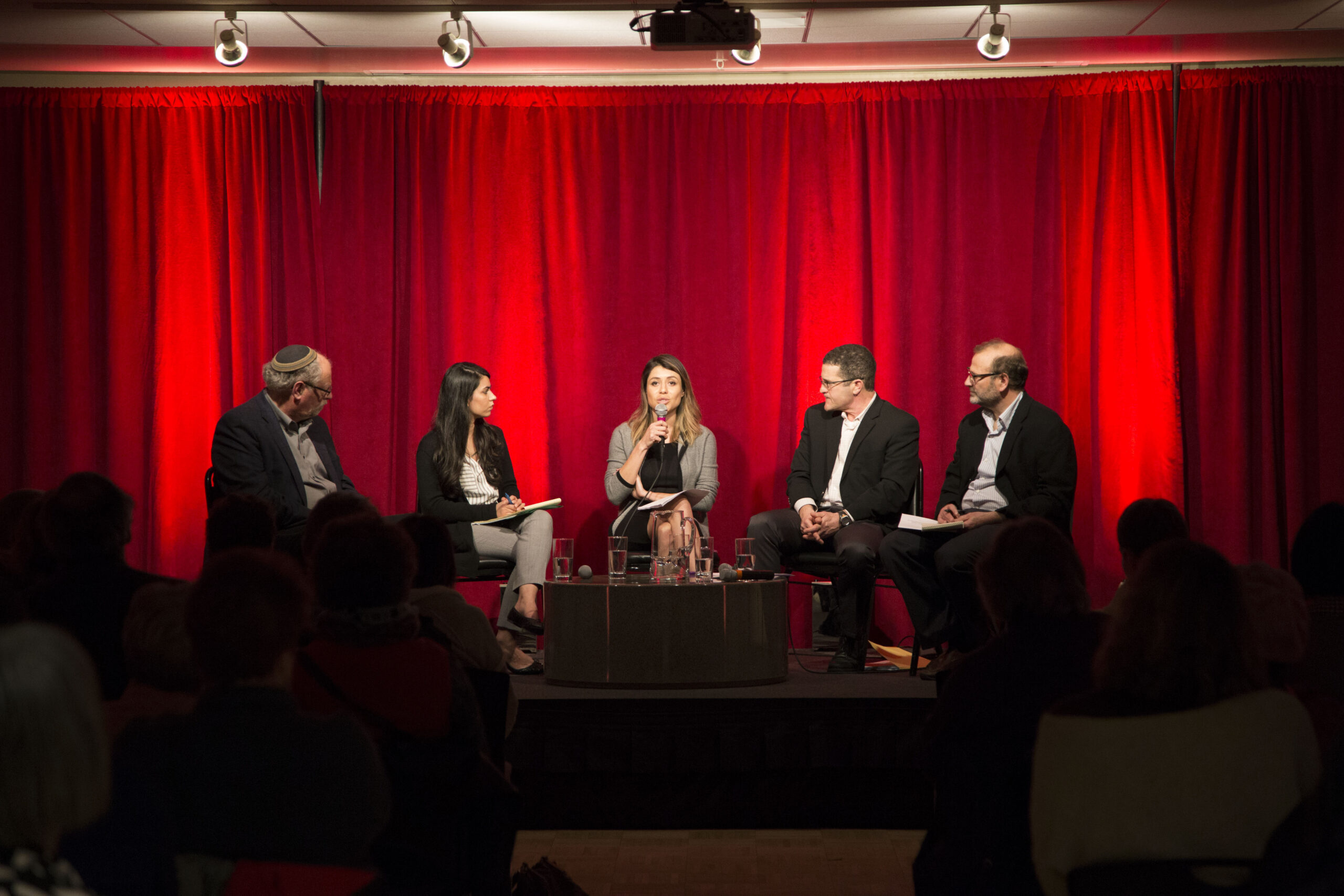 four panelists and moderator on seated on stage