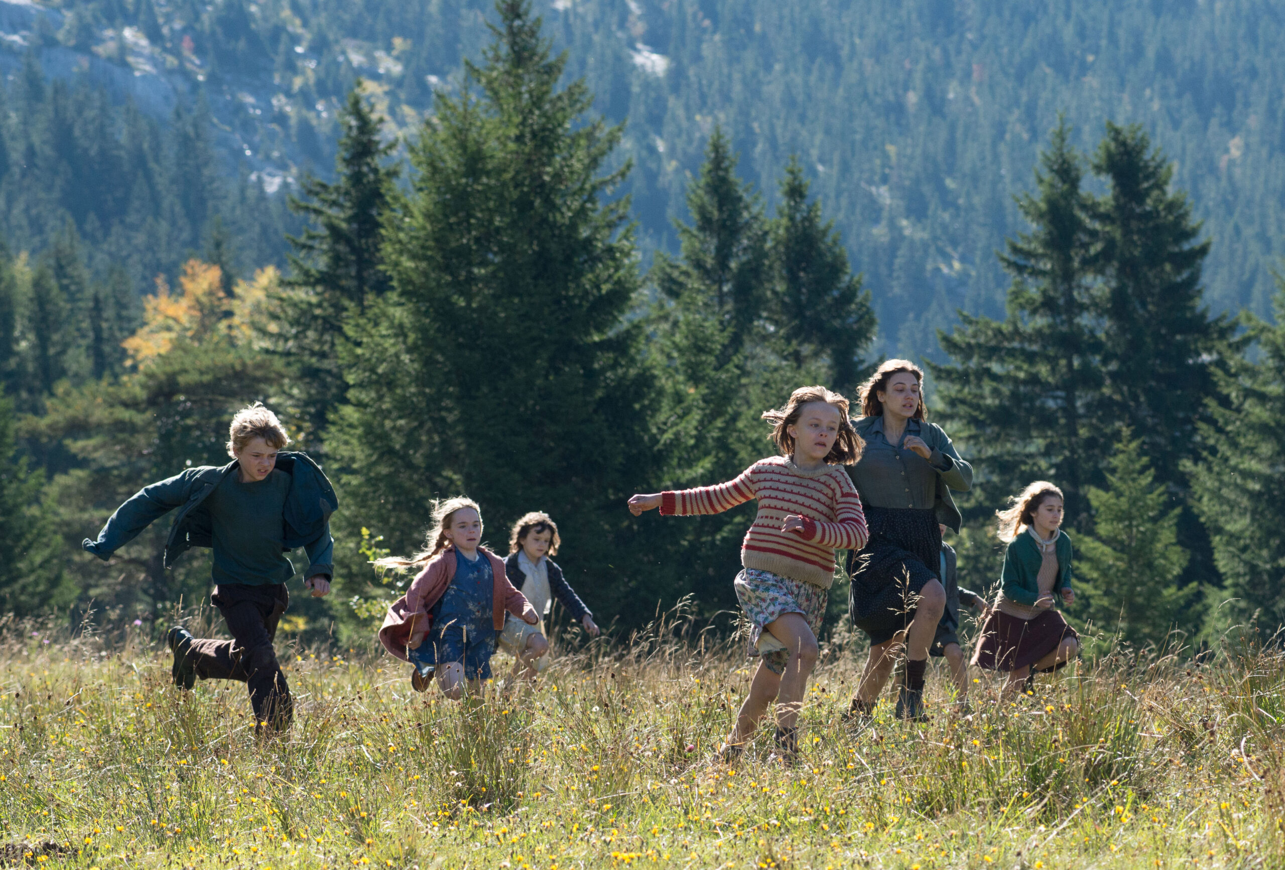 children run across a grassy field