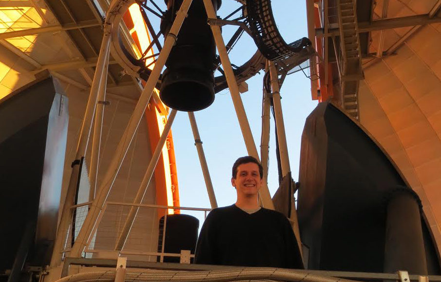 medford poses inside the dome of a large telescope