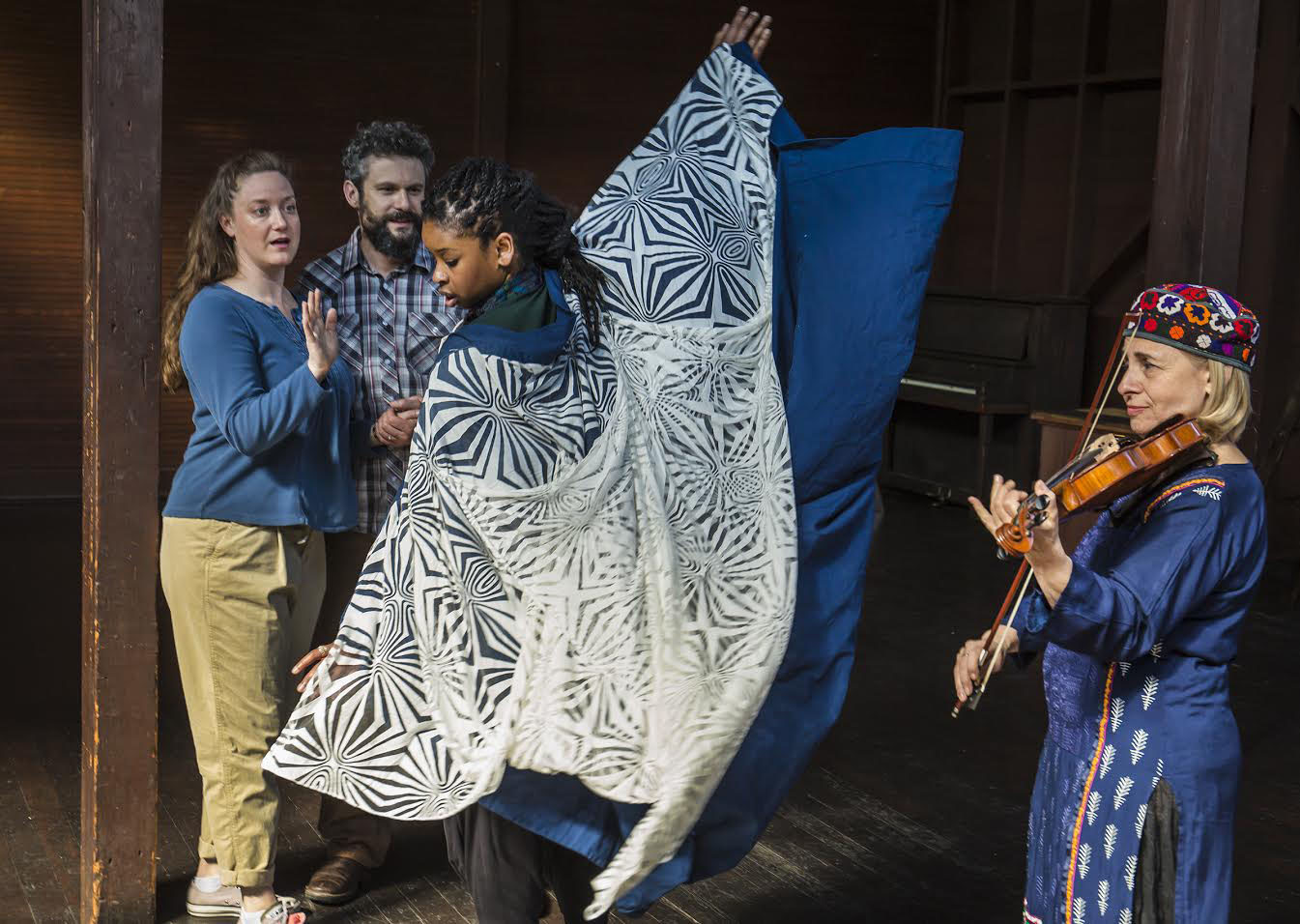 Clason and Monin look on as Brown twirls in a colorful cape. Braves plays violin.