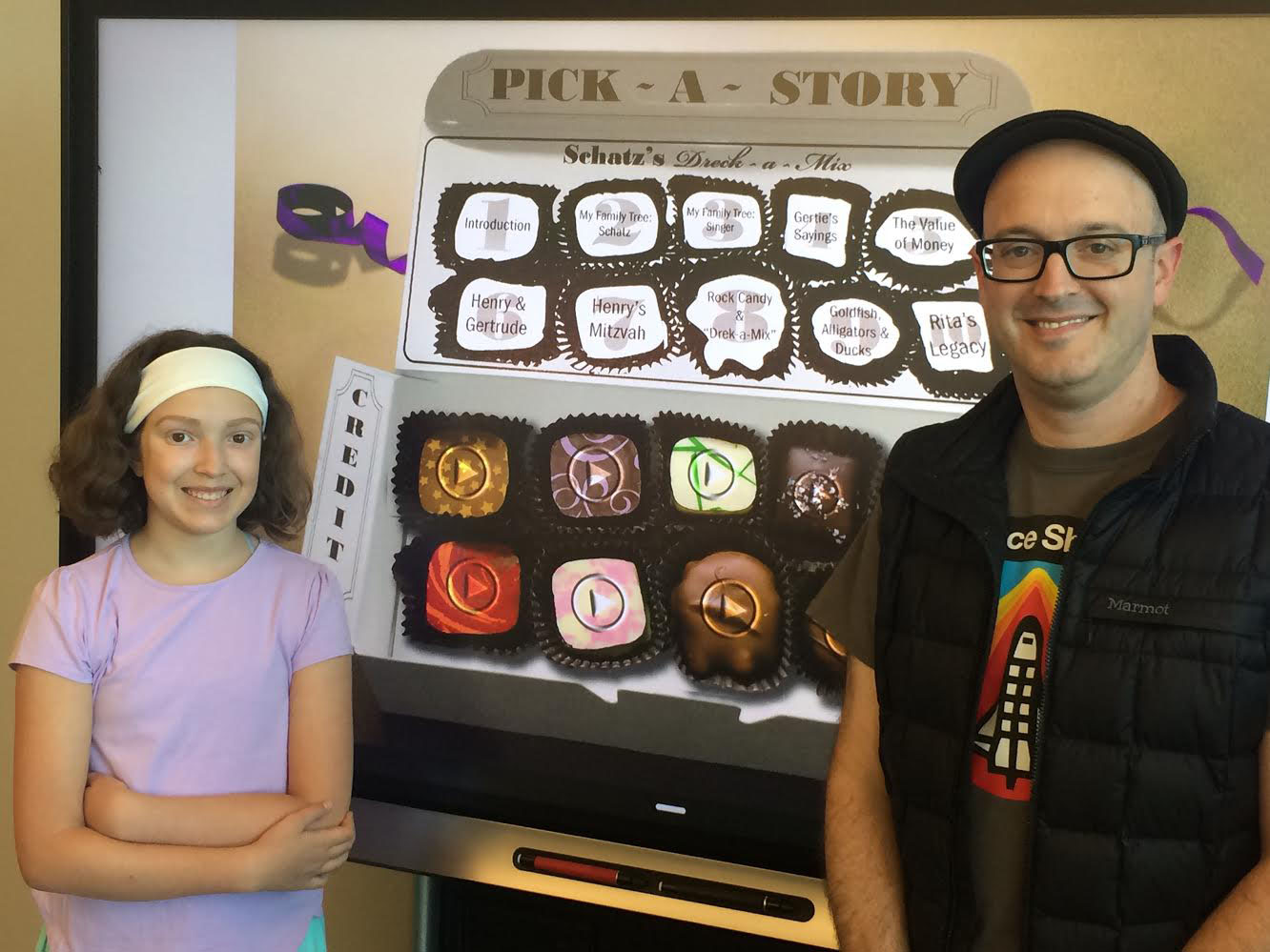 father and daughter stand in front of a big science fair-type display