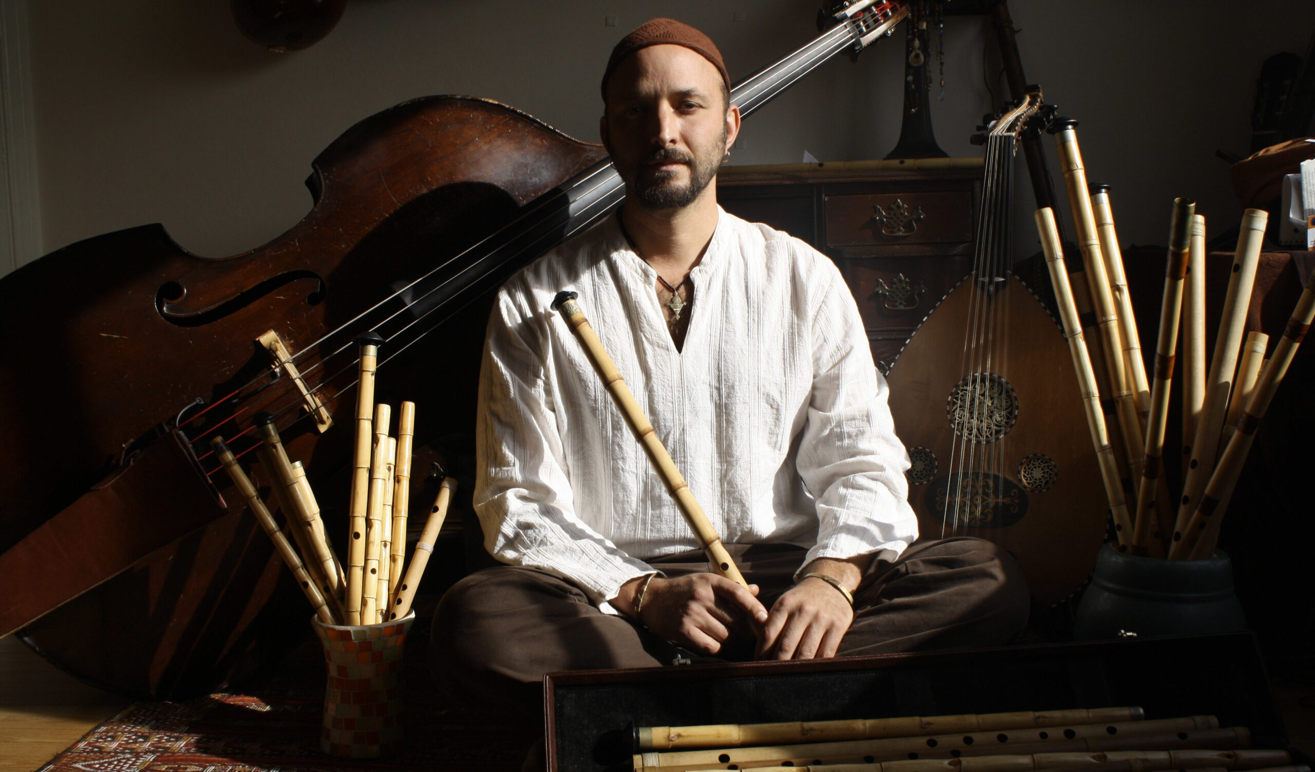 Sills sits on the ground among his many instruments