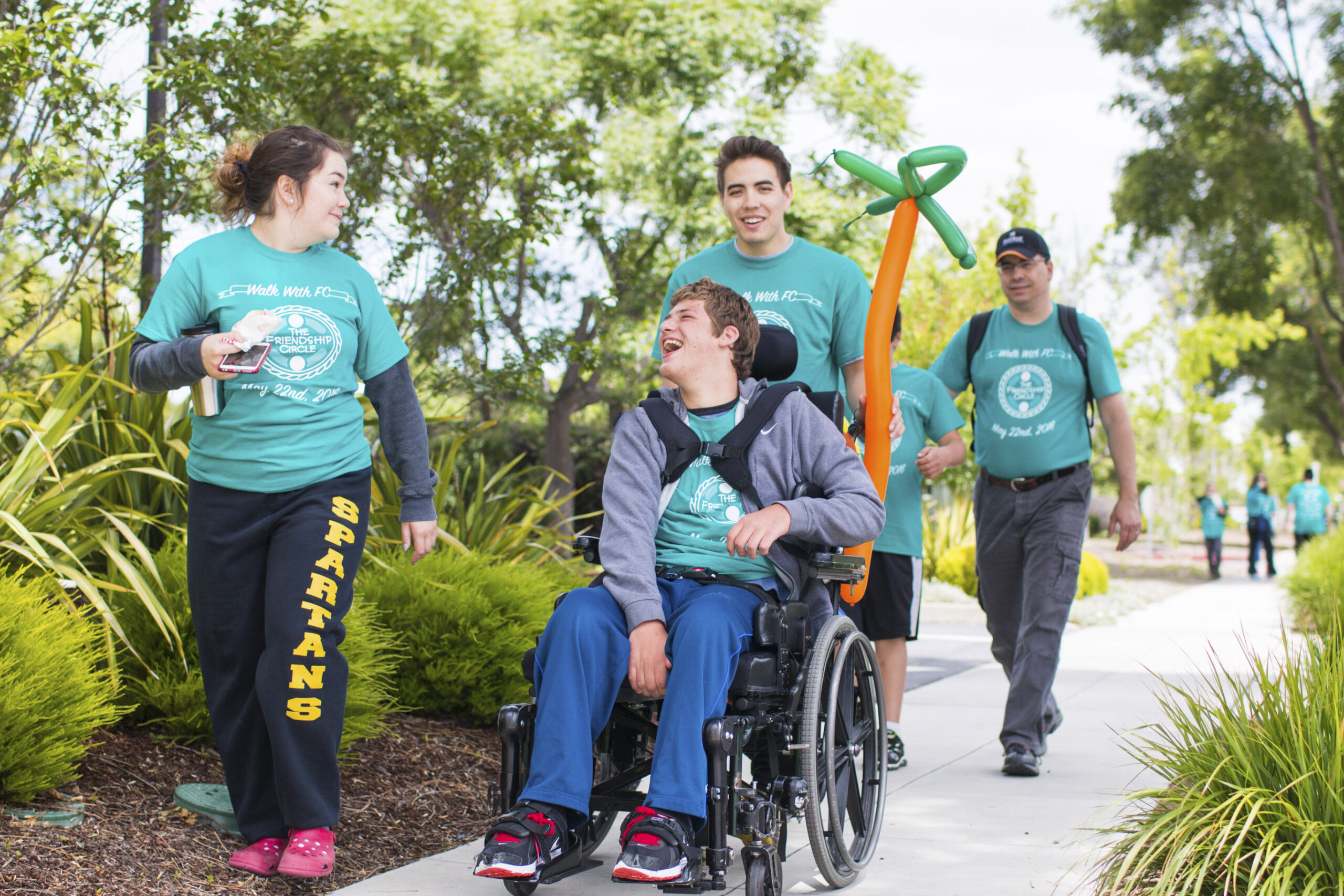 Walk-a-Thon marchers with disabled teen in a wheelchair.