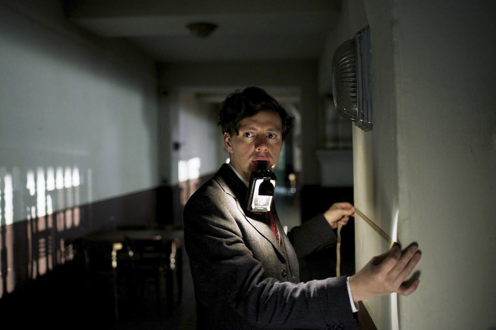 a suspicious looking man in a dark hallway