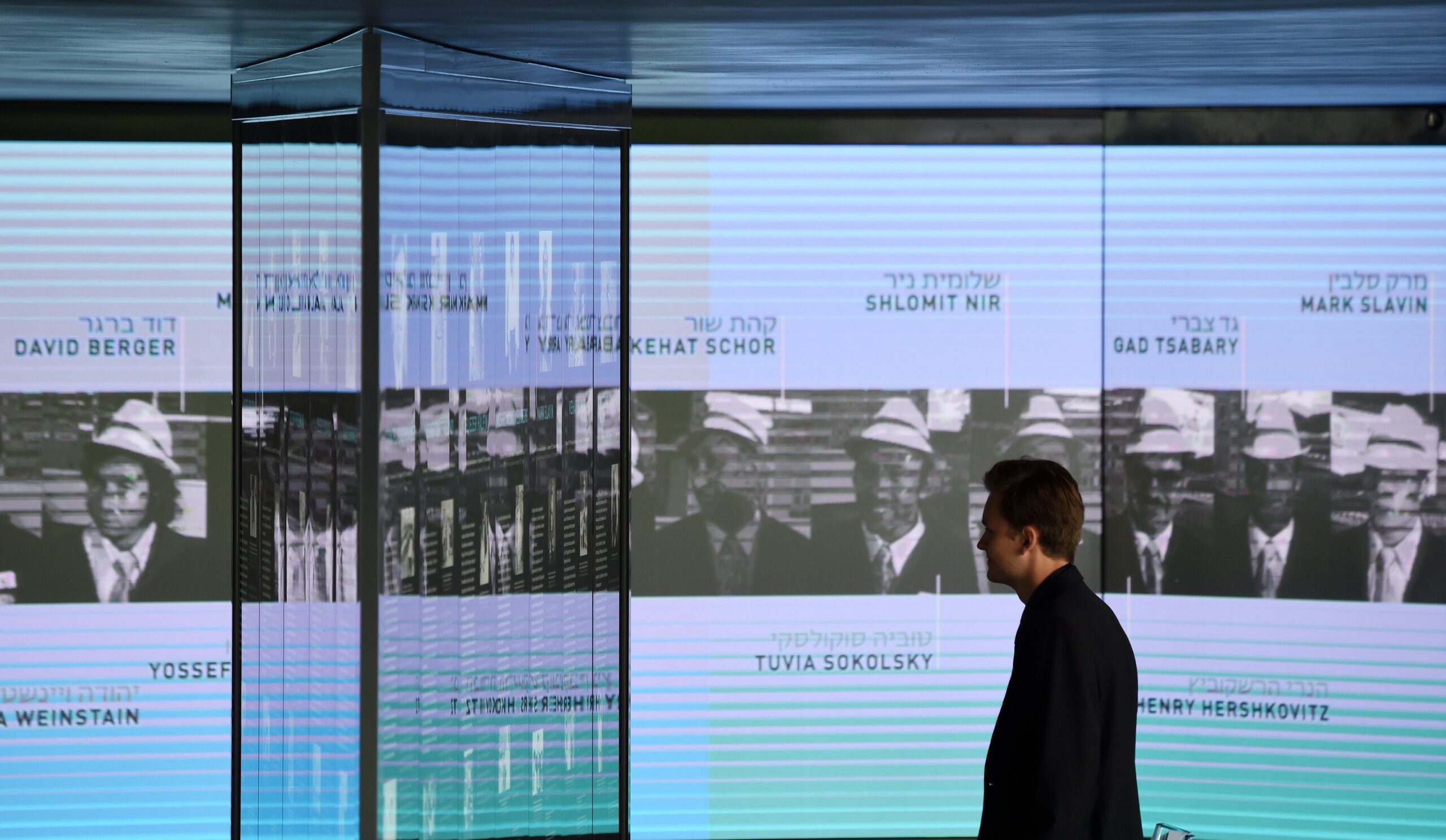 A visitor looking at the portraits of the Israeli Olympians murdered at the 1972 Munich games at a new memorial in the German city, Sept. 6, 2017 (Photo/JTA-Christof Stache-AFP-Getty Images)