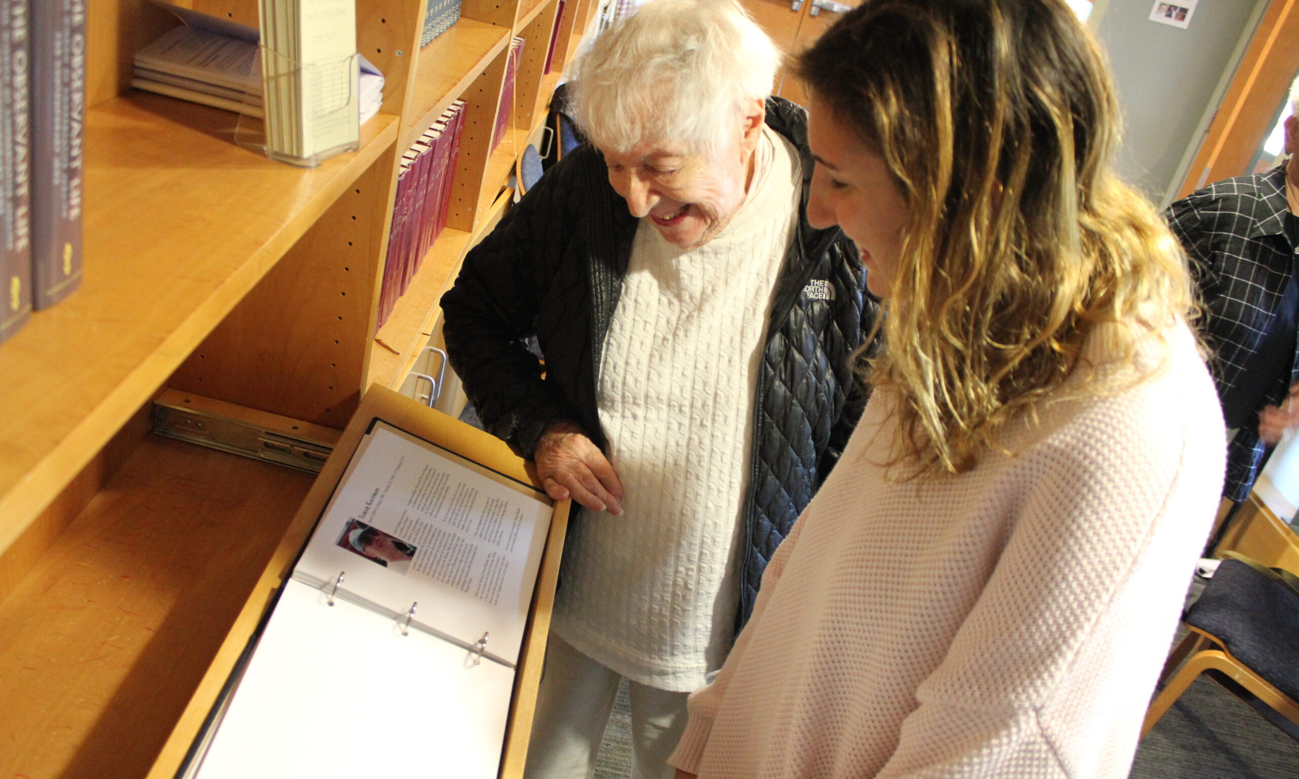 Miriam Lowe (left) and Amy Midanik-Blum admire the Netivot Shalom Yizkor book. (Photo/David A.M. Wilensky)