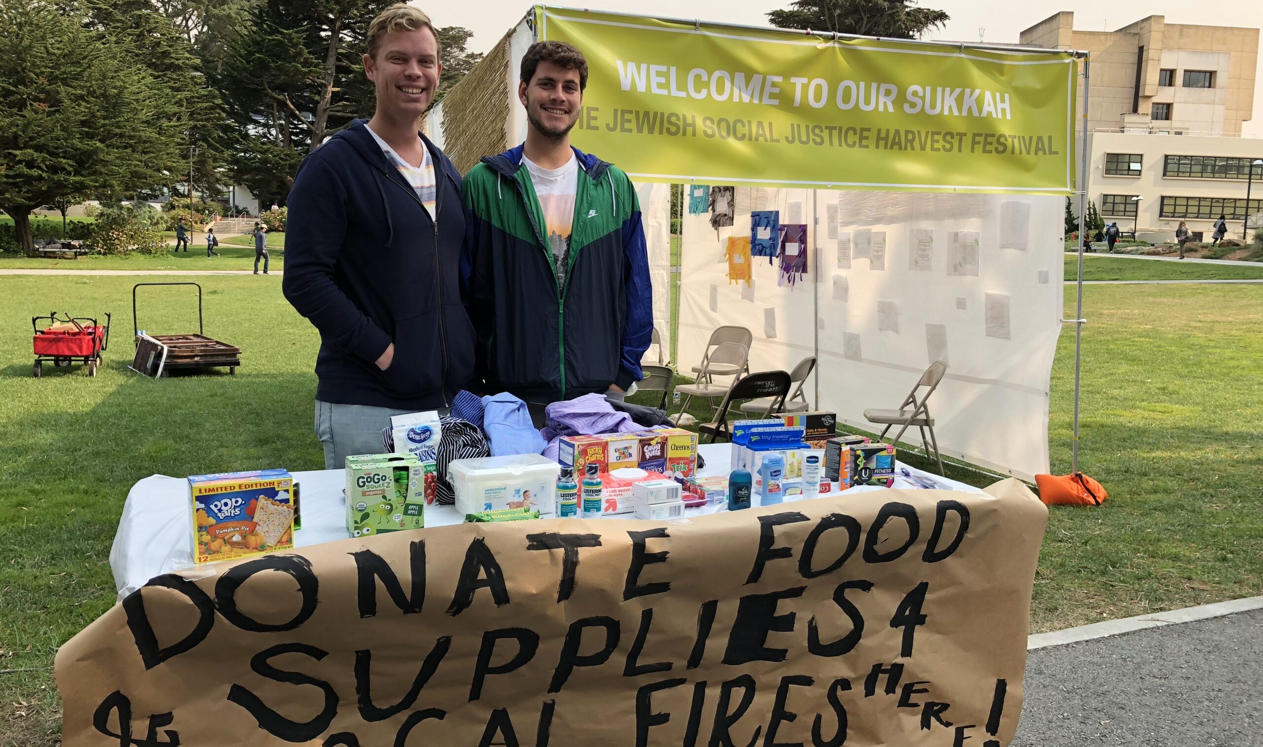 SF Hillel students Benjamin Gaster (left) and Jake Scheinberg collecting donations in front of their campus sukkah. (Photo/Courtesy SF Hillel)