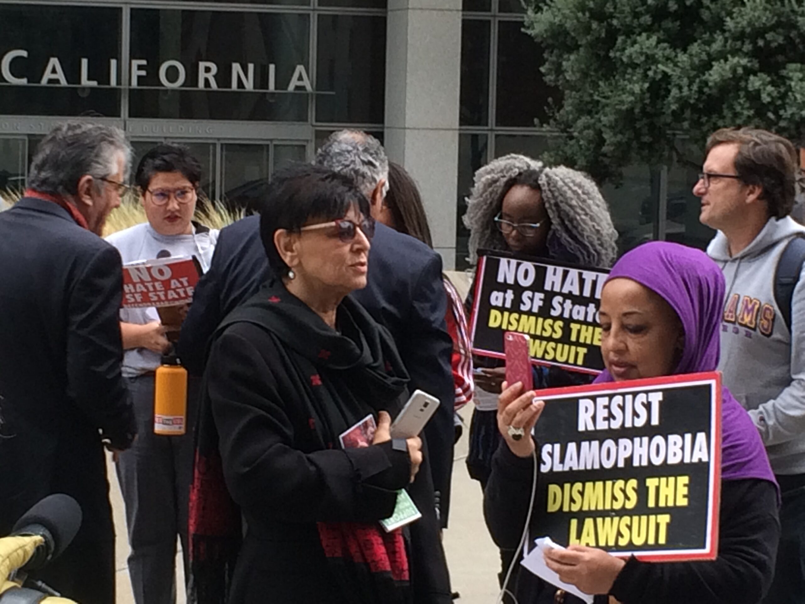 Professor Rabab Abdulhadi (dark glasses) and Saida Adem (in scarf) join others to oppose lawsuit against SFSU outside the courthouse. (Photo/Rob Gloster)