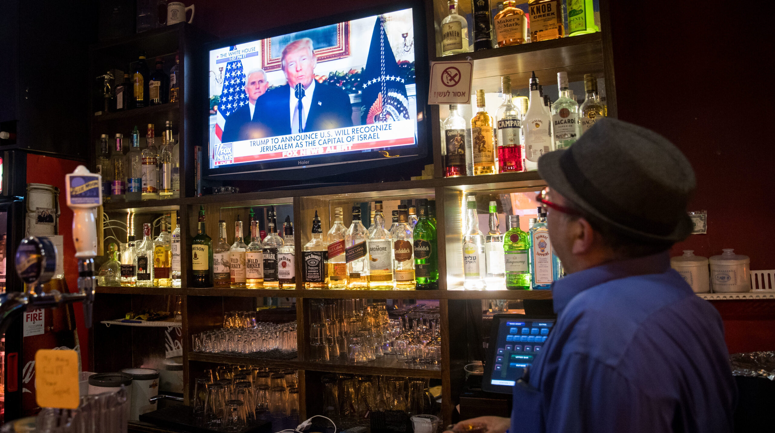 A patron at a Jerusalem pub watches as President Donald Trump recognizes the city as Israel's capital, Dec. 6, 2017. (Photo/JTA-Yonatan Sindel-Flash90)