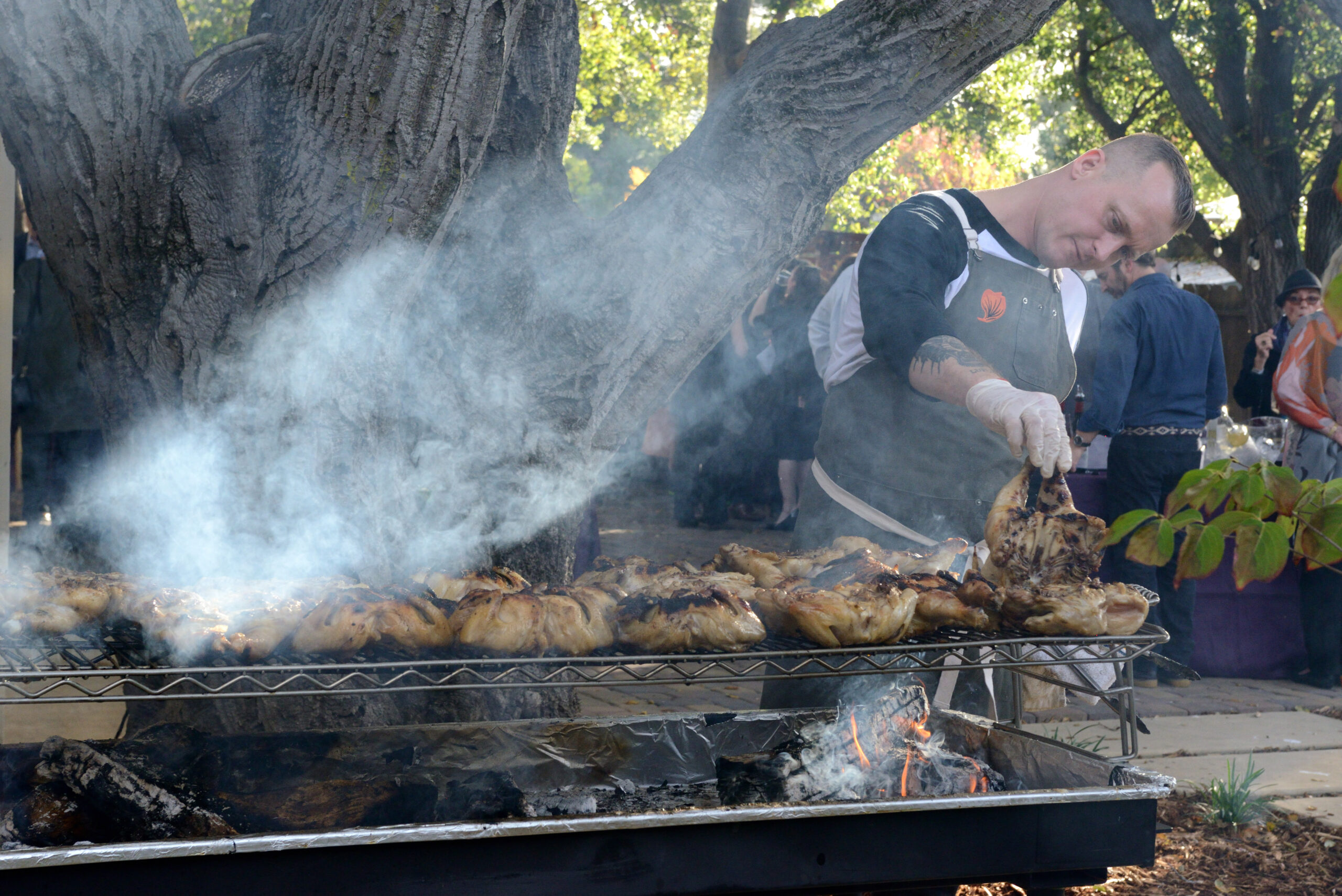 Chef David Nayfield flips his wood-fired chicken. (Photo/Janna Waldinger, Art & Clarity Photography)