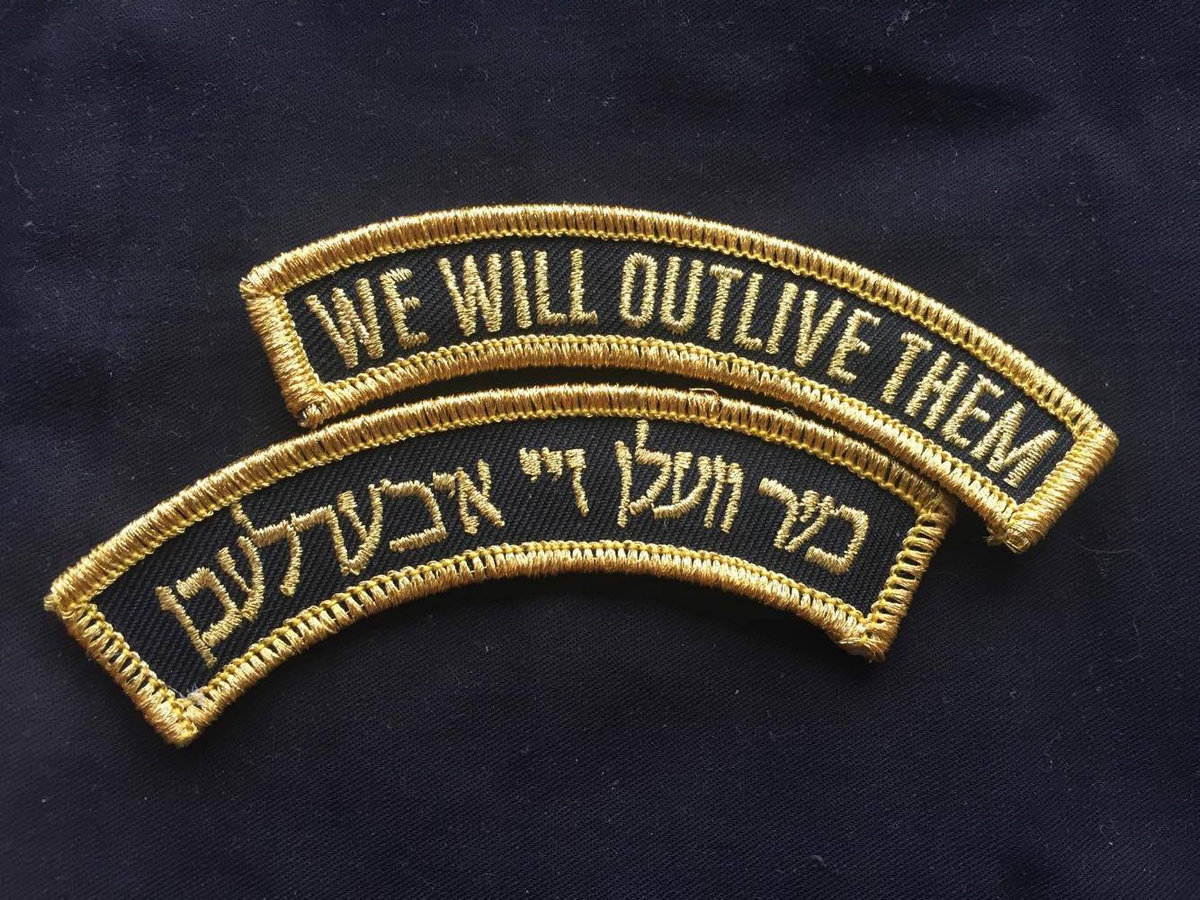 two black patches with gold wording — one patch in english, one patch in yiddish