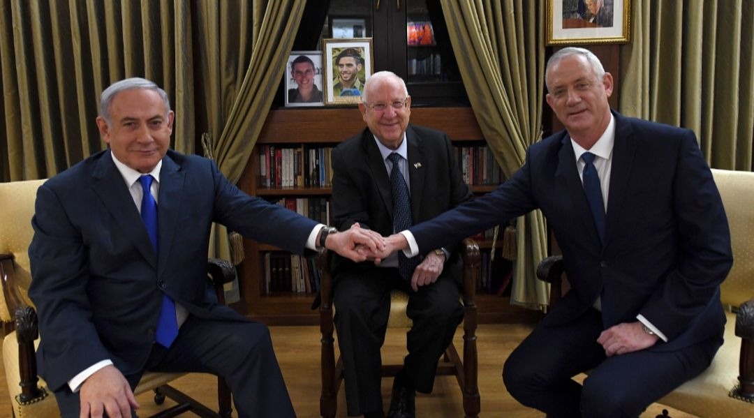 the three men sit smiling; gantz and bibi hold hands