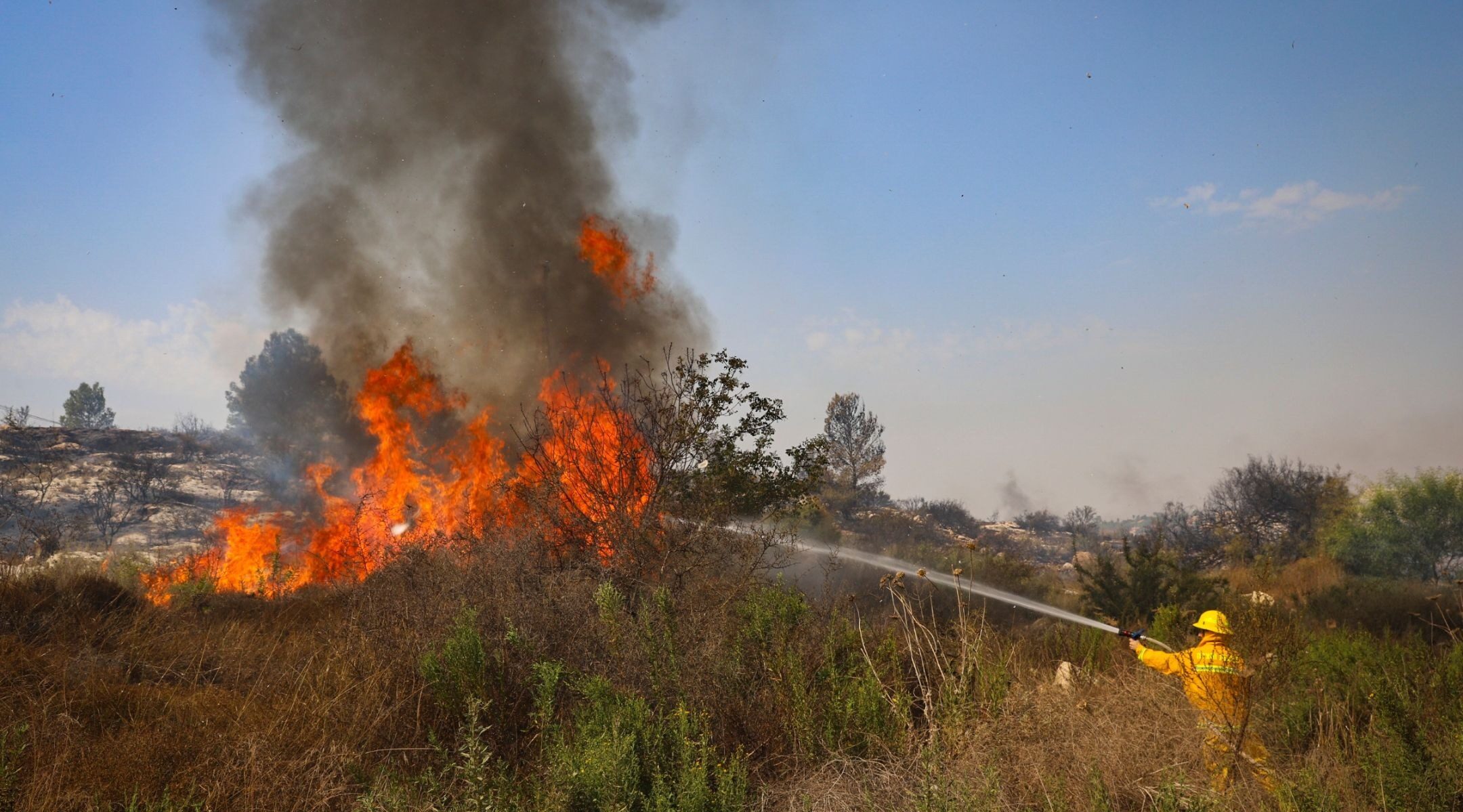 A firefighter works to extinguish a fire near the Kfar HaOranim settlement in the West Bank on Oct. 9, 2020. (Photo/JTA-Yossi Aloni-Flash90)