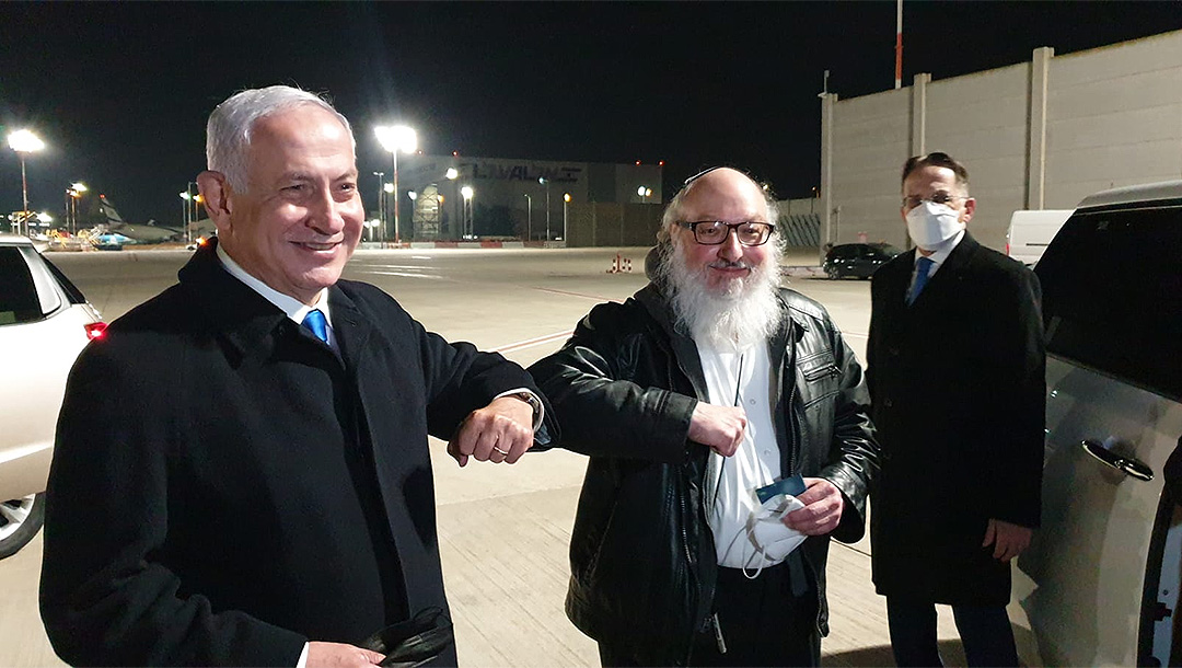 Two men bump elbows at Israeli airport