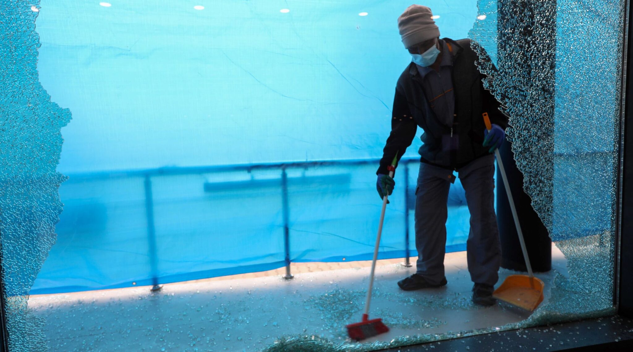 A worker clears shattered glass outside a shop damaged by a rocket attack the previous night in Erbil, the capital of the Iraq's Kurdish autonomous region. (Photo/JTA-Safin Hamed-AFP via Getty Images)
