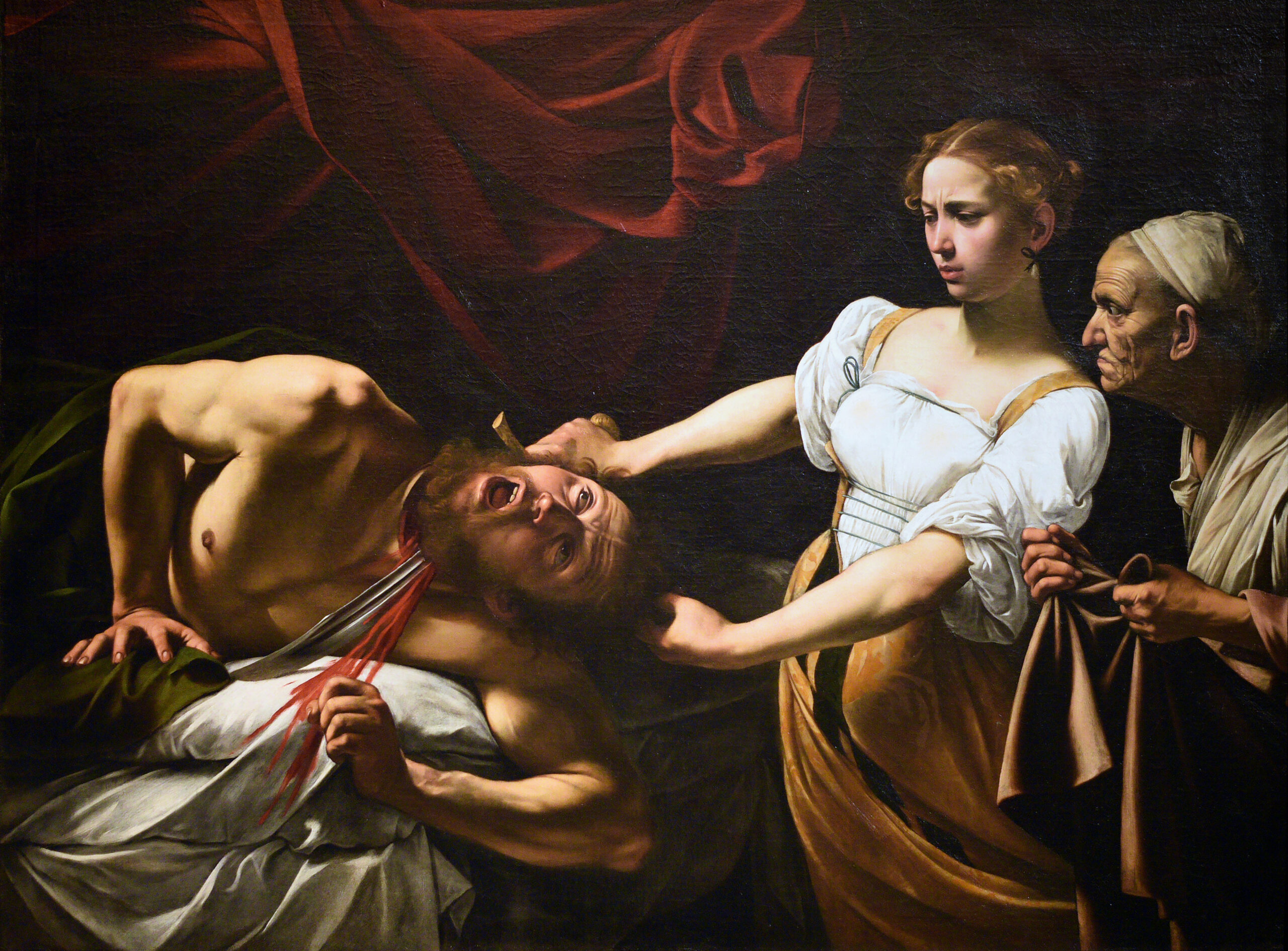 Renaissance painting of a young woman cutting off the head of man with a sword