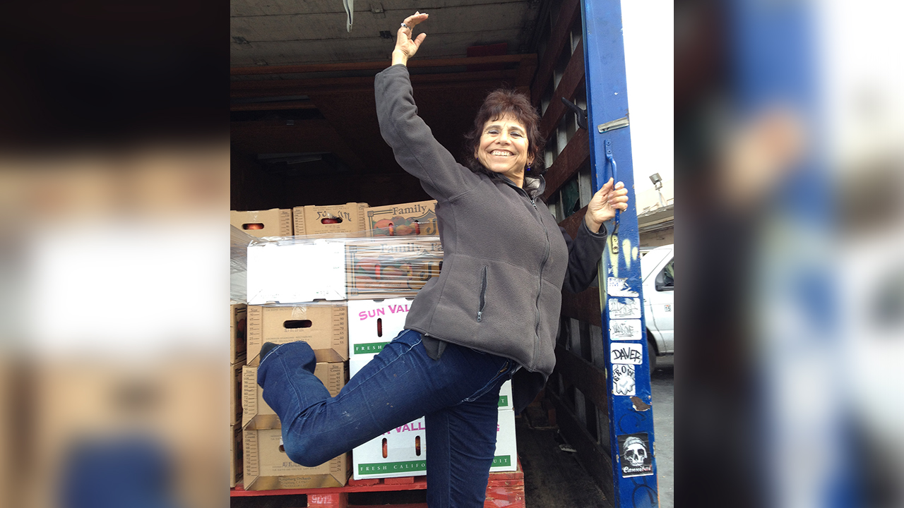 Beth Abrams strikes a ballet pose in a truck of donated food.