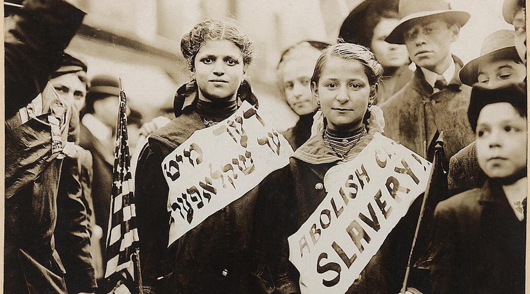 Two girls wear banners with the slogan "Abolish child slavery" in English and Yiddish, probably taken during May 1, 1909 labor parade in New York City. (Photo/JTA-Library of Congress Prints and Photographs Division)