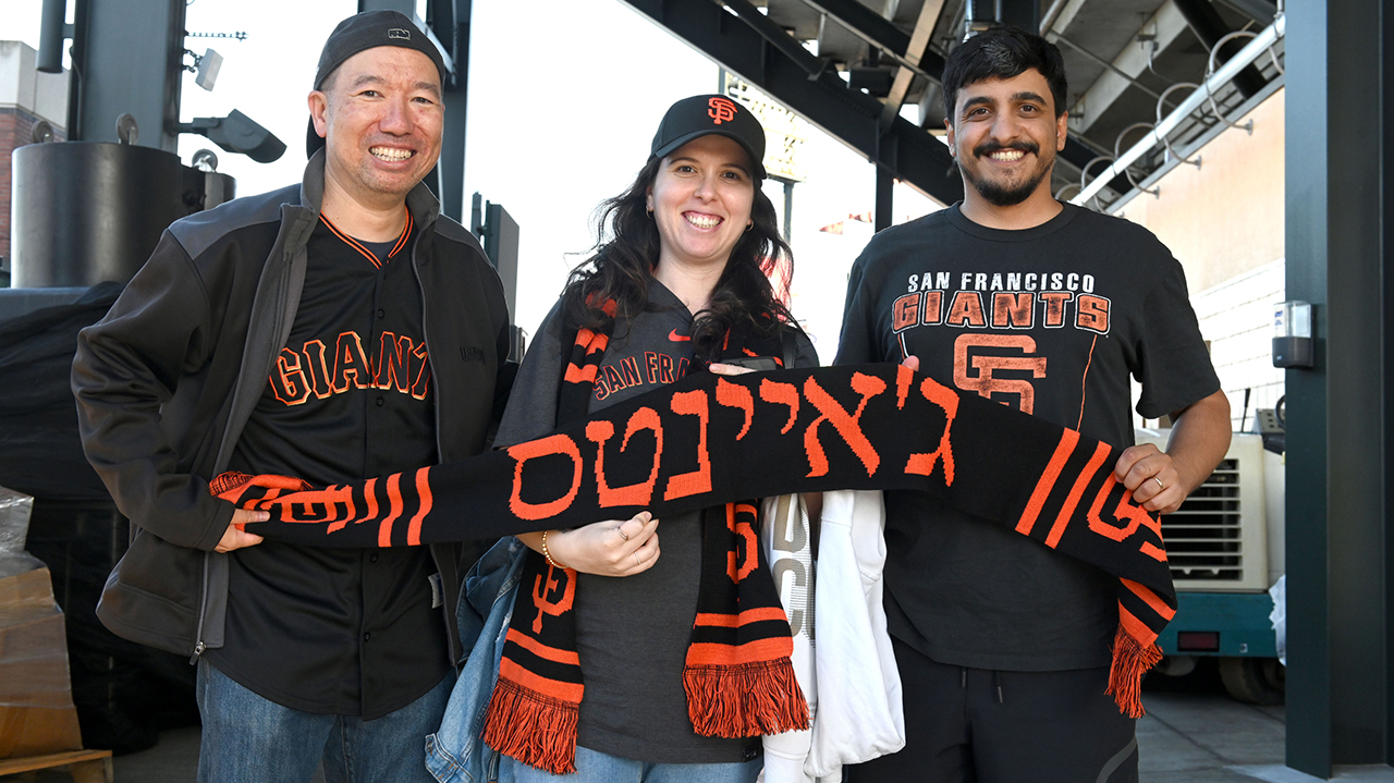 (From left) Stan Wong, Natalie Vaysman Mama and Maor Mama with their giveaway Hebrew Giants scarves on Jewish Heritage Night at Oracle Park, Aug. 15. (Photo/Aaron Levy-Wolins)