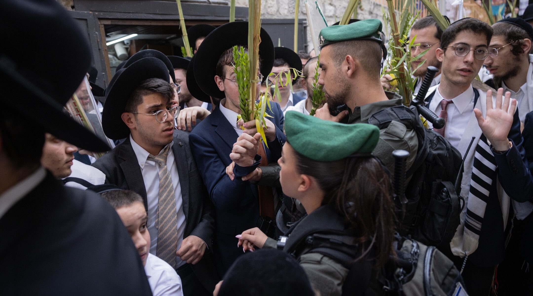 Israeli border police stand guard near Orthodox Jews in the Old City’s Christian quarter, after an incident in which Haredi Orthodox Jews spat at a Christian procession carrying a cross through Jerusalem's Old City. (Photo/JTA-Chaim Goldberg-Flash90)