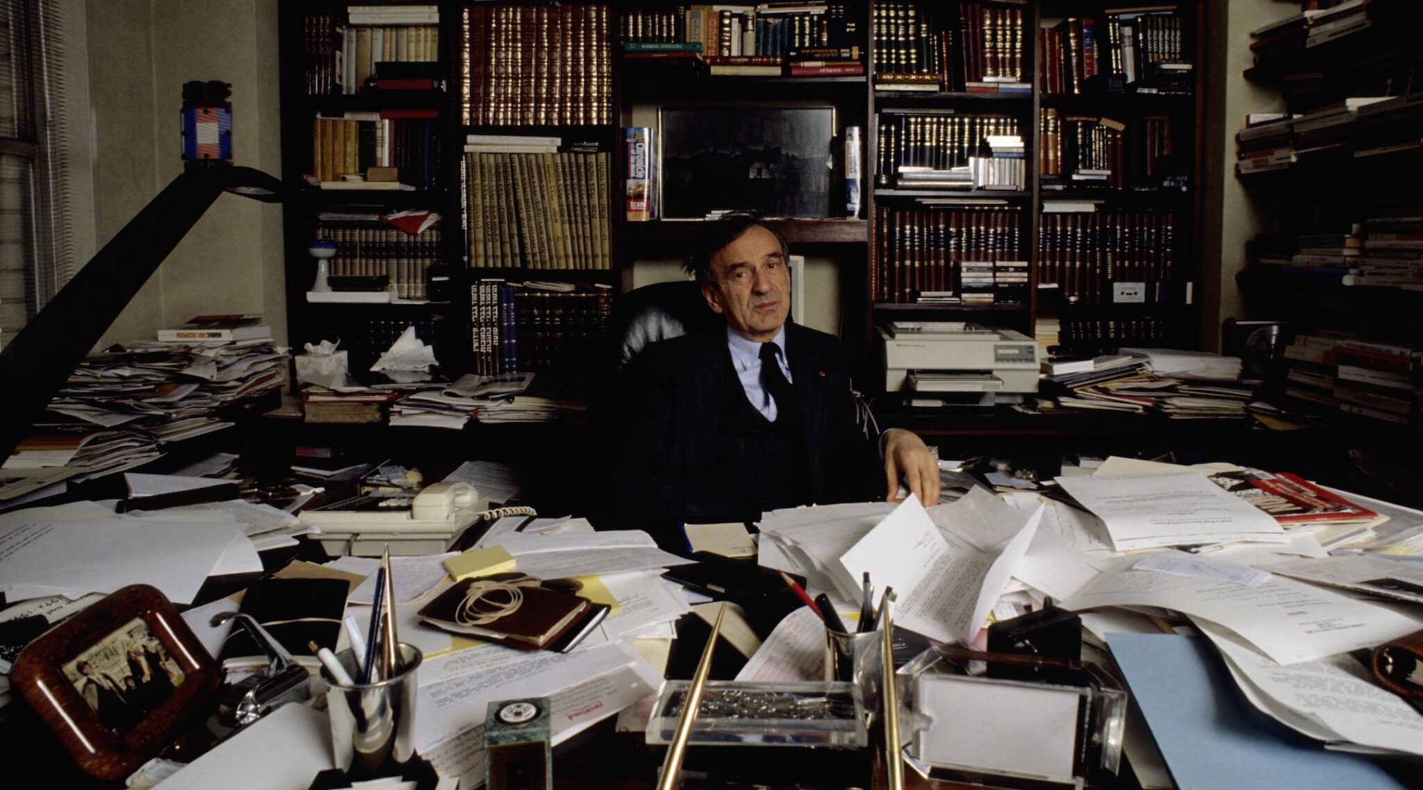 Elie Wiesel sits at a desk