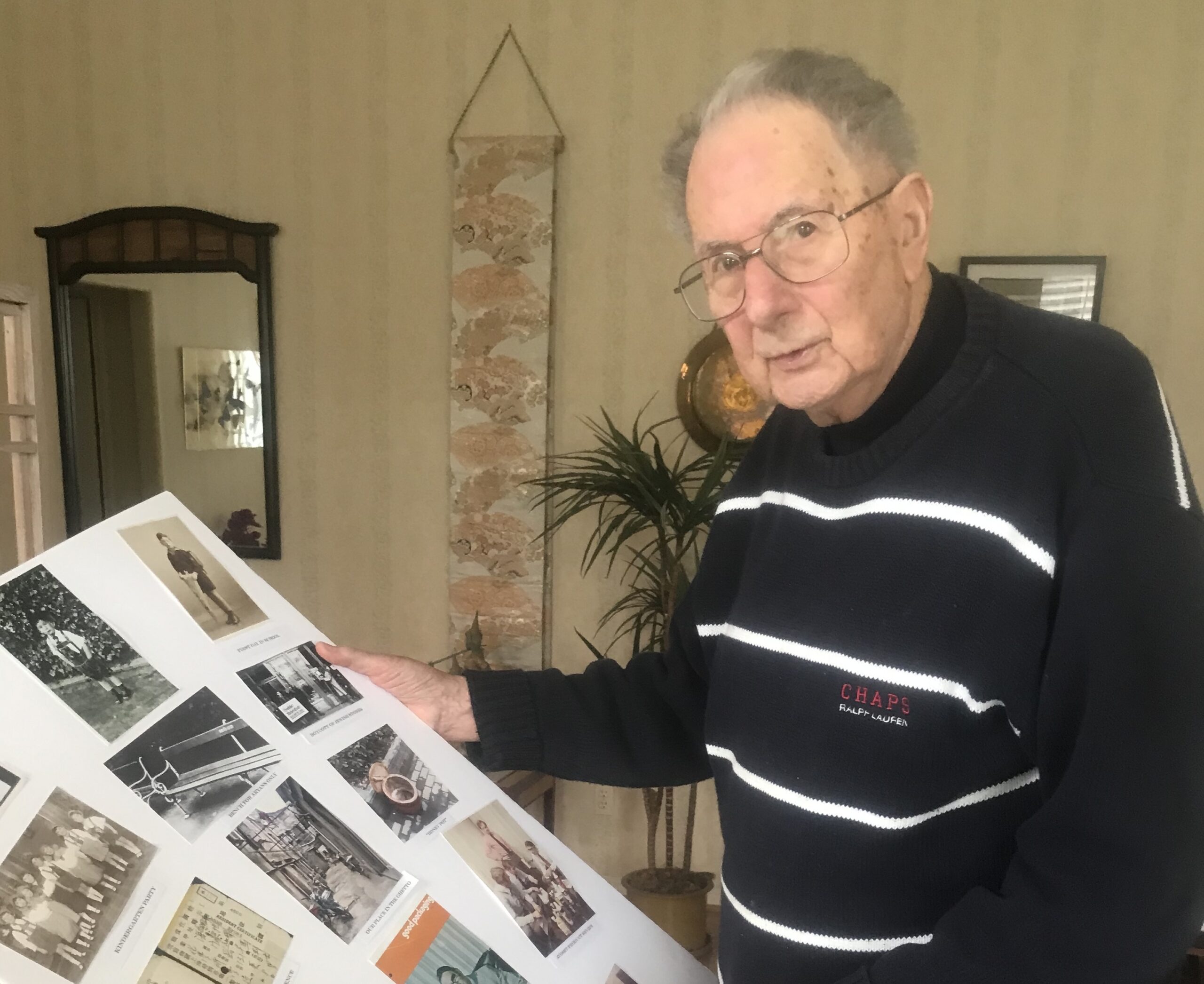 Ernie Glaser with a posterboard of old photos he prepared for his 100th birthday party in March. (Photo/Sue Fishkoff)