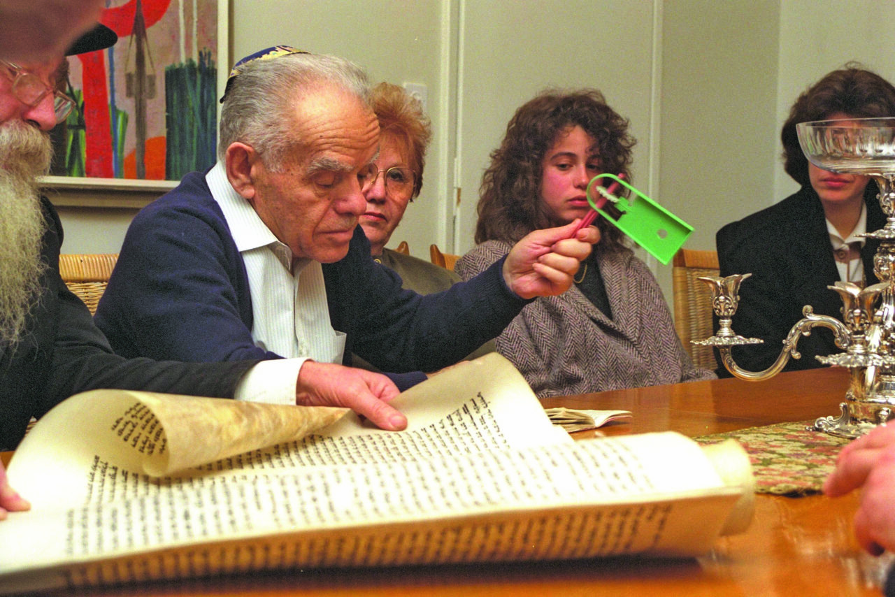 Prime Minister Yitzhak Shamir holds a grogger during a Megillah reading at his home in Jerusalem on Purim 1991. (Photo/Israel Government Press Office)