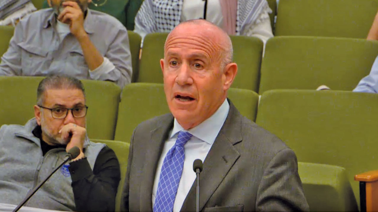 During the March 19 city council meeting, Sacramento Mayor Darrell Steinberg positioned himself behind the lectern so he could face his fellow councilmembers to talk about the compromise resolution on Gaza. (Screenshot/MetroCable14)