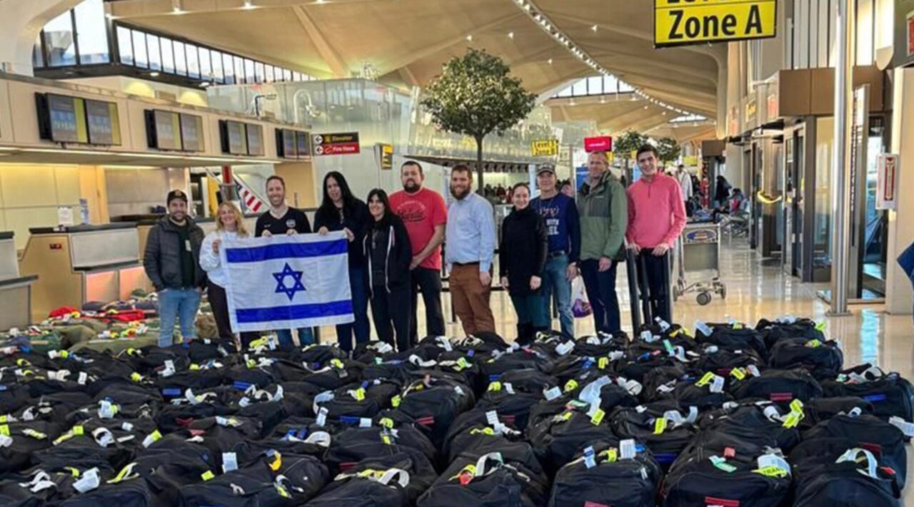 People stand at airport with dozens of black bags