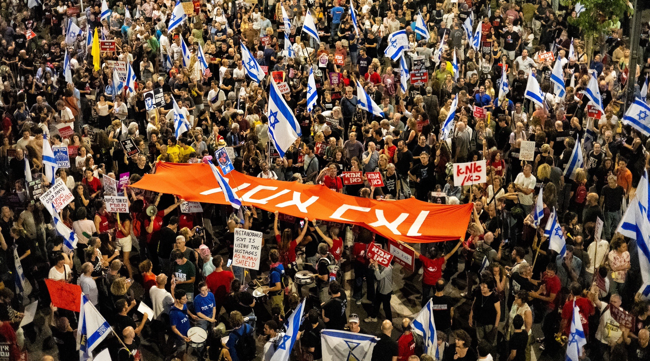 Thousands of Israeli demonstrators in an anti-government protest call for a hostage deal and ending the war, Tel Aviv, May 18, 2024. The sign in Hebrew reads, "Mother is here." (Photo/JTA/Yahel Gazit/Middle East Images/AFP via Getty Images)