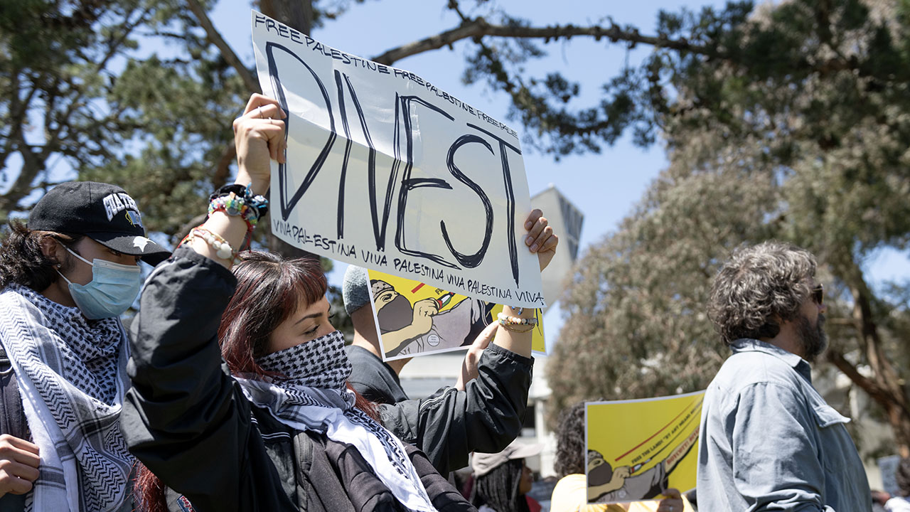 A protester holds a sign that reads “Divest” and “Free Palestine” in English and Spanish during a demonstration at San Francisco State University in April 2024. (Photo/Aaron Levy-Wolins)