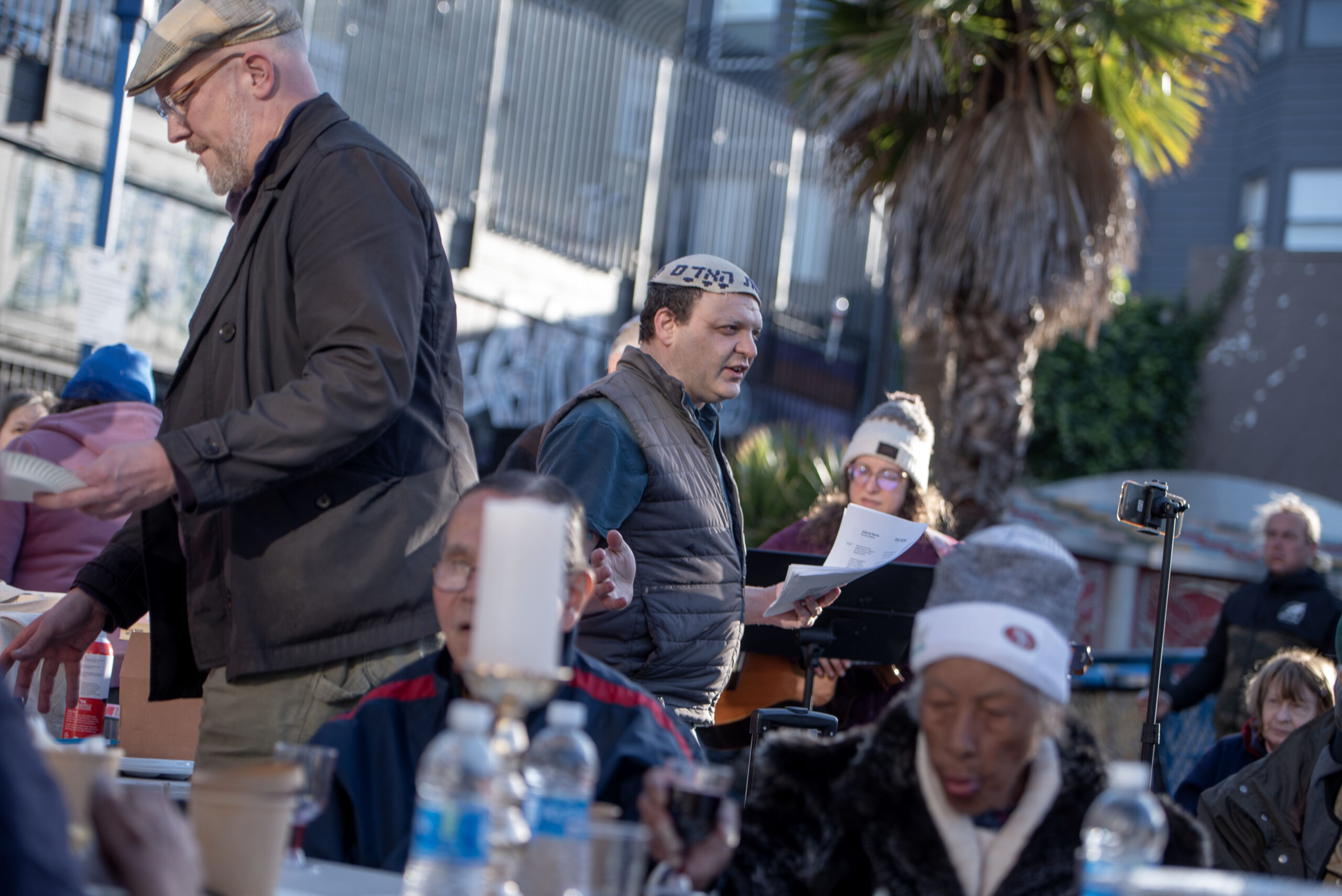 Rabbi Jeremy Sher (middle) of the San Francisco Night Ministry leads a street seder for unhoused people put on by and Congregations Ner Tamid, Sha’ar Zahav, Keneset Halev and Sherith Israel at the 16th Street BART plaza in San Francisco on April 26, 2024. (Aaron Levy-Wolins/J. Staff)
