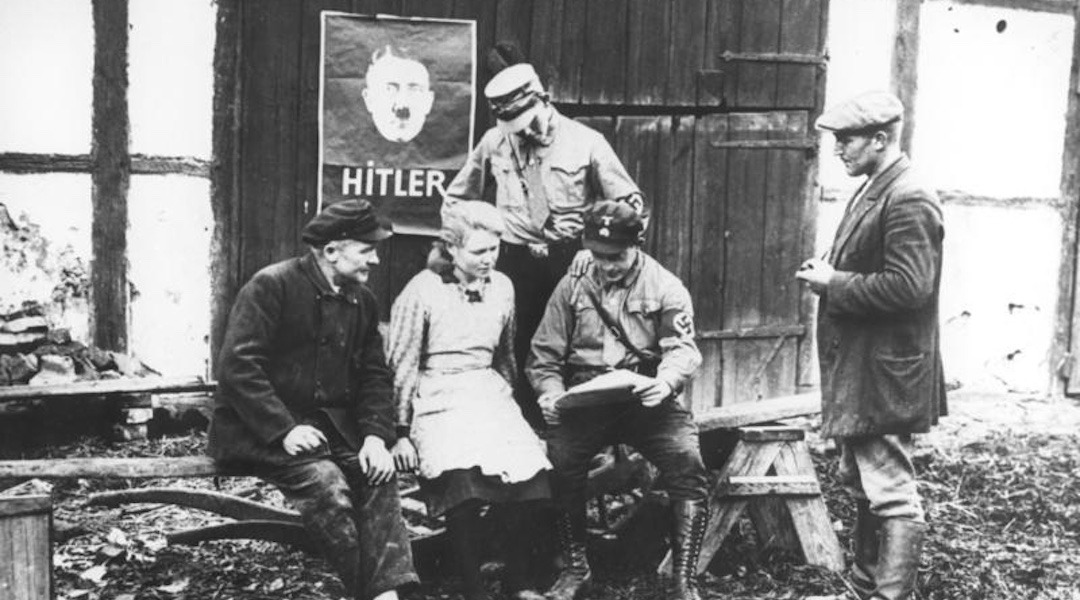 Nazi loyalists in Mecklenburg, Germany read news about the upcoming parliamentary elections, summer 1932. A campaign poster for Hitler is at rear. (German Federal Archives/Wikimedia Commons)