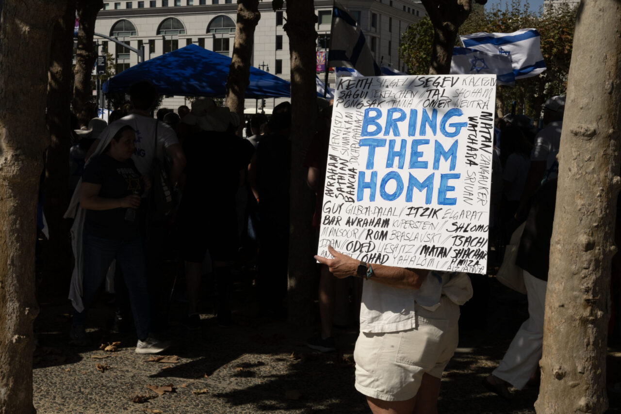 Deborah Goldeen holds a sign that says “Bring Them Home” with names of hostages around it during a rally in support of Israel and the hostages still held by Hamas at Civic Center Plaza in San Francisco on Sunday, Oct. 6, 2024. (Aaron Levy-Wolins/J. Staff)