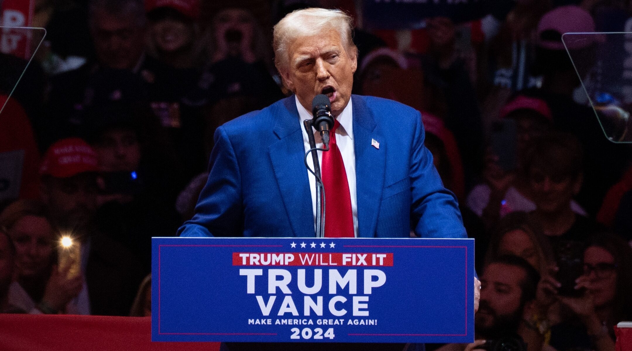 Trump stands at a lectern that says "Trump Vance on it"