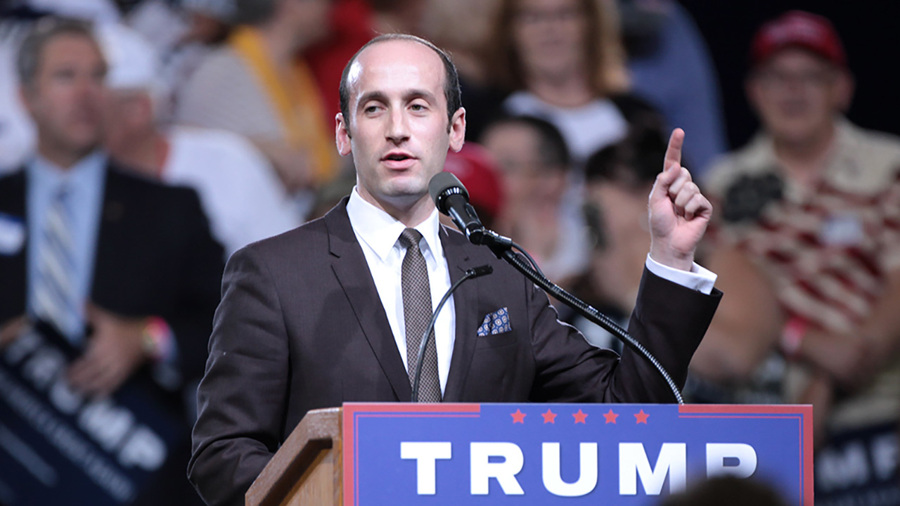 Miller speaks as lectern labeled "TRUMP"