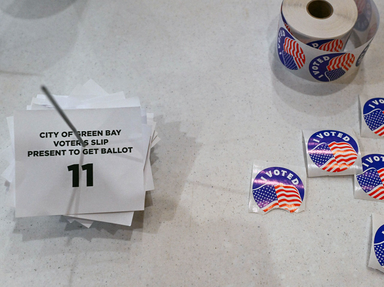"I Voted" stickers strewn about a gray table