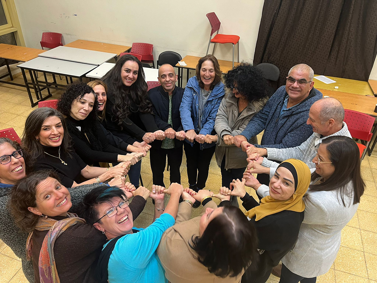 a group of people stand in a circle smiling