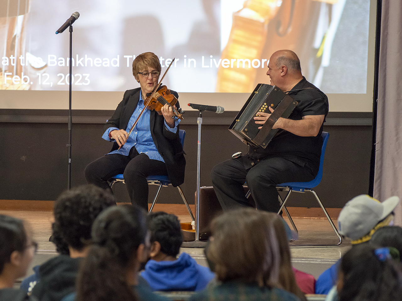 a woman playing violin and a man playing accordion on stage