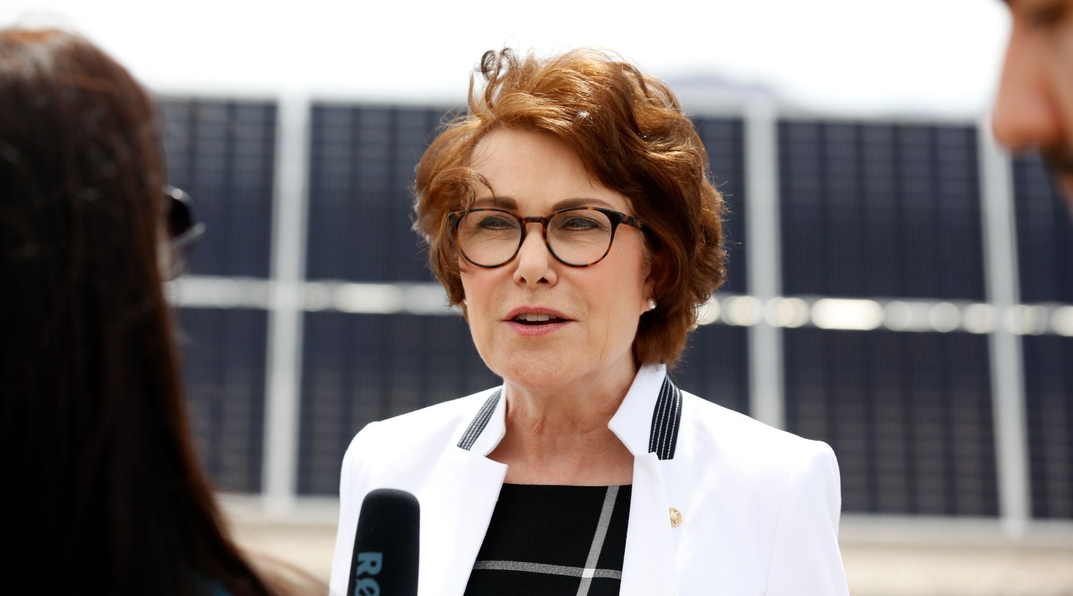 Rosen speaks to a reporter holding a microphone