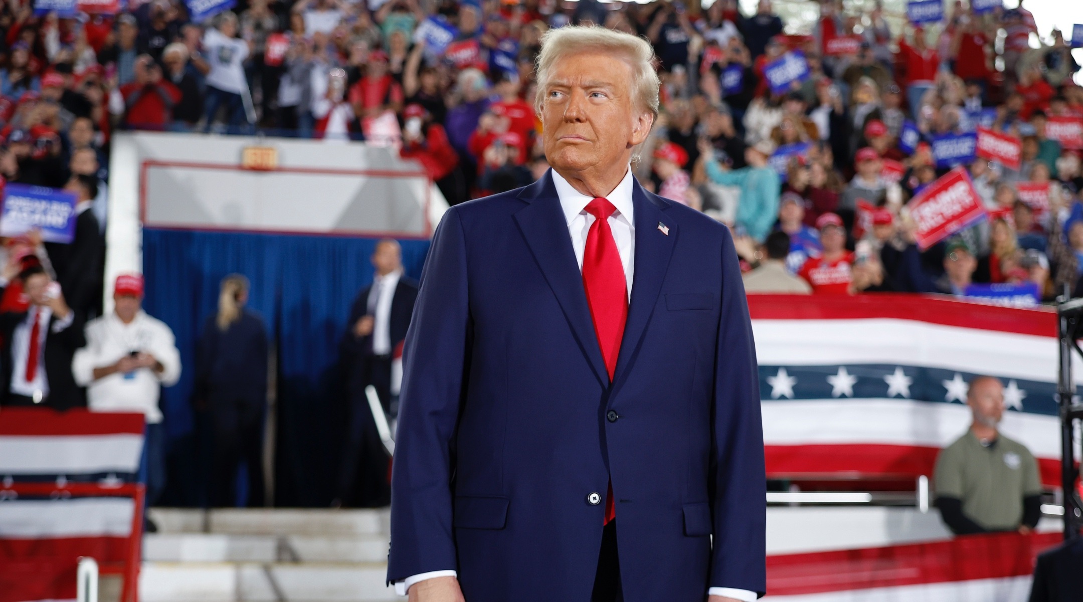 Trump stands on stage before a large crowd