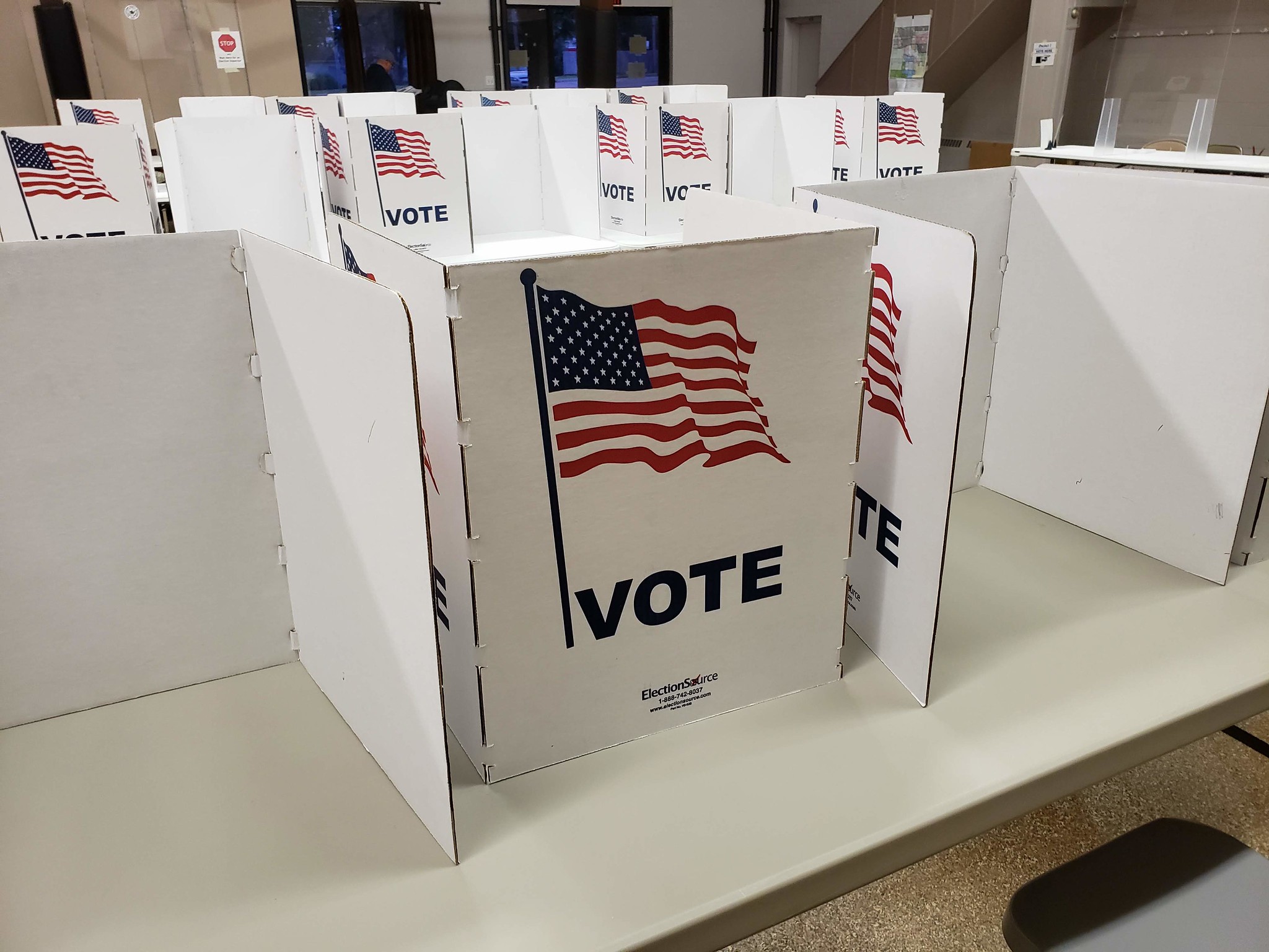 a series of folding cardboard voting blinders set up on tables