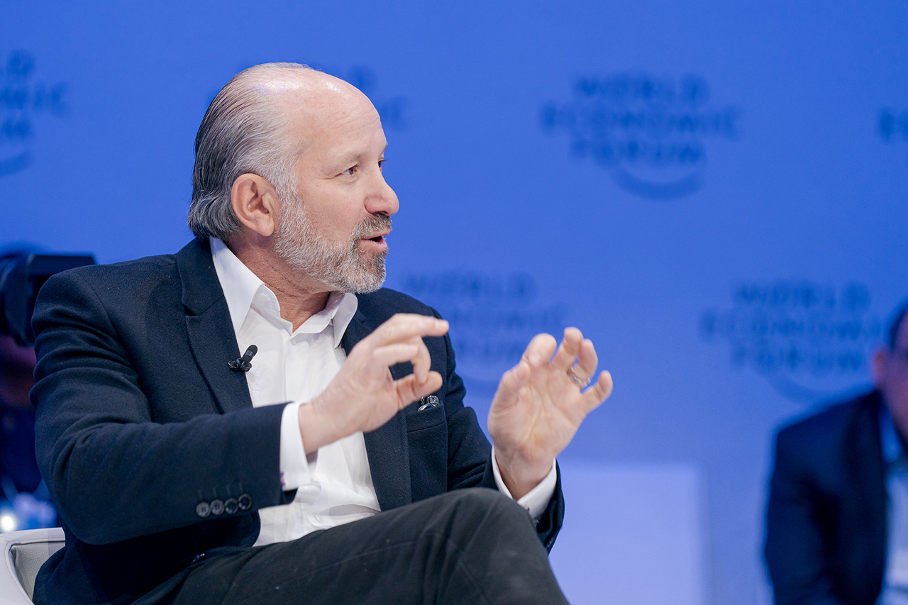 Lutnick speaks seated on a stage