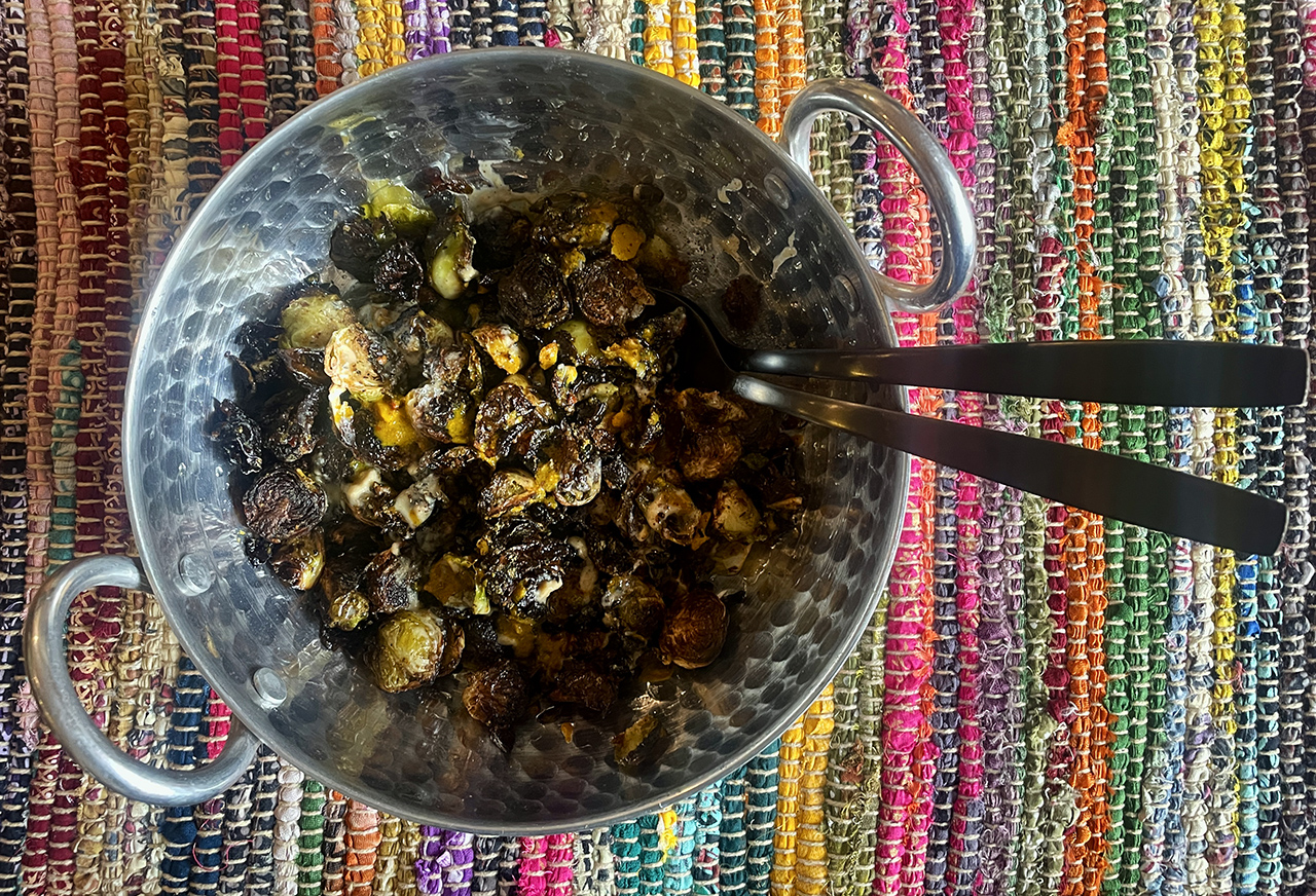 a metal bowl filled with cooked Brussels sprouts