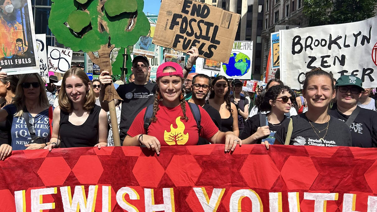 a group of young people march in a protest holding a banner that says "Jewish Youth"