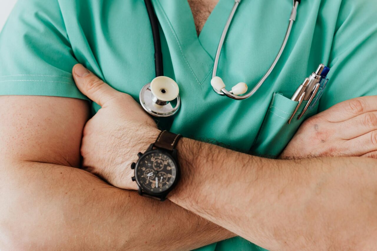 torso of a male doctor with stethoscope and crossed arms