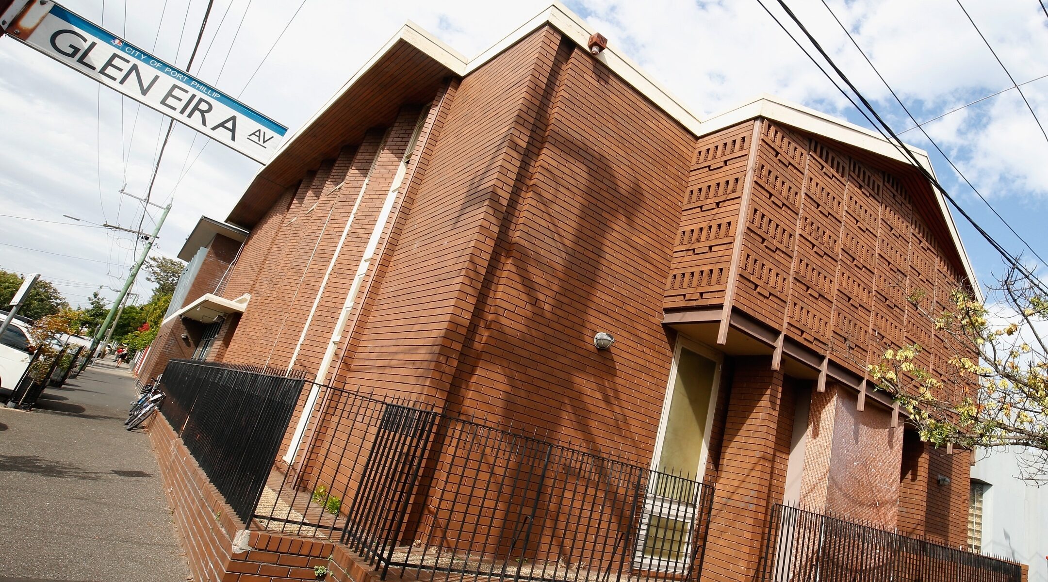 a boxy brick building on a partly cloudy day